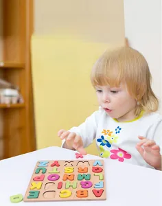 Close-up of colorful 3D wooden alphabet blocks and puzzle board for toddler learning