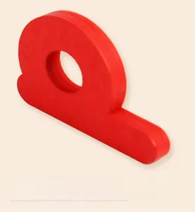 Macro detail of laser-cut red wooden letter block with smooth rounded edges for kids