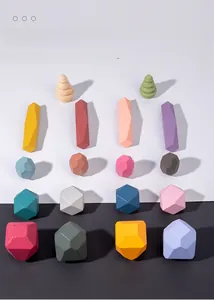 Flat lay of colorful geometric wooden stones on a high-contrast black and white background