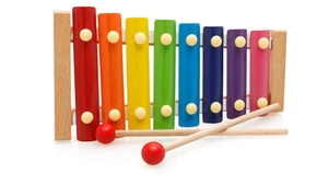 Macro shot of 8-note wooden xylophone with rainbow metal keys and two red-tipped mallets