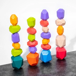 Macro shot of colorful stone-shaped wooden balancing blocks on a textured stone surface