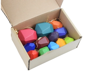 Close-up of colorful wooden balance stones in a kraft gift box with paper fillers