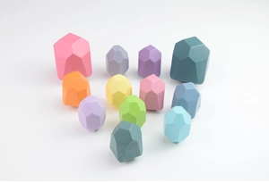 Macro shot of stacking macaron wooden blocks with a smooth geometric stone-like texture