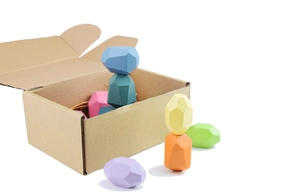 Detailed view of colorful wooden balance stones stacked on a brown cardboard box