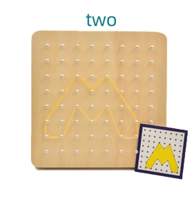 Macro detail of a wooden geoboard showing an M shape formed with yellow rubber bands