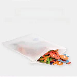 Detail of wooden alphabet blocks inside a white drawstring storage bag for kids