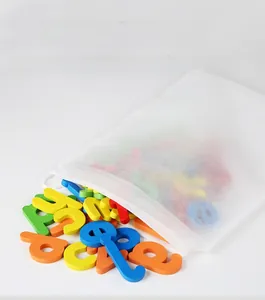 Gros plan de blocs de lettres et chiffres en bois colorés dans un sac de rangement blanc