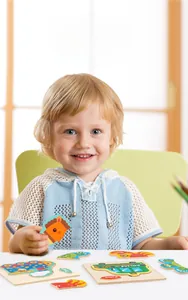 Detail of toddler boy playing with wooden animal puzzles for early skill development
