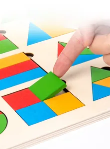 Close-up of child's hand picking colorful geometric wooden blocks from Montessori base