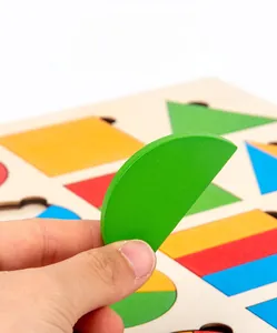 Macro shot of large wooden geometric blocks being picked up by hand for motor skills