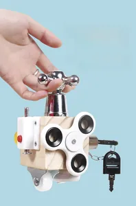 Macro detail of toddler hands operating a wooden Montessori busy cube with metal knobs