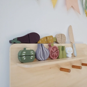Dettaglio del set di verdure in legno per bambini con coltello su scaffale nordico