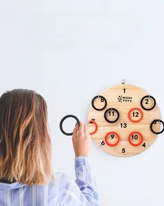 Action shot of wood ring toss board game with red and black rings on white wall