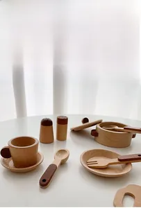 Macro detail of natural beech wood kitchen toy set showing cups and mini pot