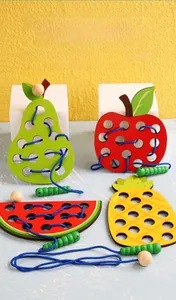 Macro detail of wooden fruit lacing toy set including apple, pear, and pineapple shapes