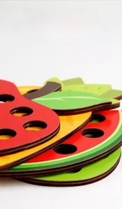 Macro view of stacked wooden fruit puzzles showing smooth laser-cut edges and bright colors