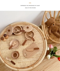 Top view of a premium wooden play kitchen set with pots and pans on a woven table
