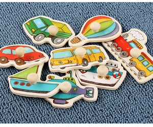Close-up of colorful wooden vehicle puzzle pieces with round knob handles for toddlers