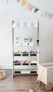 Detail view of wooden supermarket toy stand with cashier register and colorful fruits