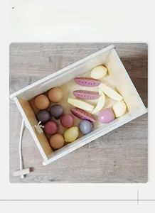 Overhead view of wooden toy shopping cart filled with colorful play fruits and vegetables