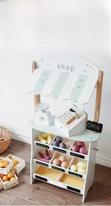 Detailed close-up of a wooden play supermarket set featuring a cash register and fruit stand