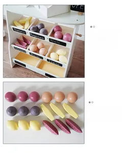 Detailed view of kids wooden grocery stand with toy fruits and vegetable baskets