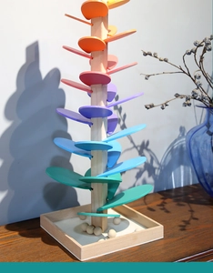 Detailed view of a colorful wooden musical marble tree toy with rainbow spiral petals