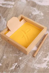 Detail view of Montessori wooden sand scraping box with golden sand and stylus