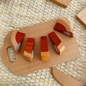 Close-up of wooden pretend play food toy set with velcro slices on a miniature board