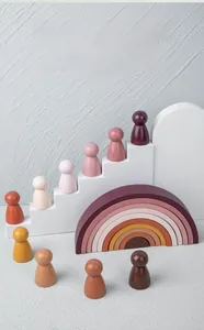Artistic layout of Morandi rainbow wooden blocks with ten matching pegged dolls on stairs