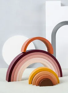 Close-up of premium wooden rainbow stacker toy showing smooth earth-toned arc blocks