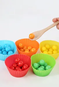 Détail de billes en bois colorées et bols en silicone pour la motricité fine enfant
