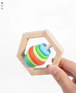 Detail of wooden baby rattle with colorful rings for sensory grip training