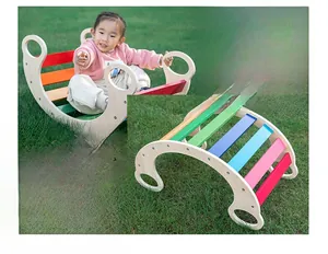 Rainbow wooden rocking chair and climbing frame for toddlers in a garden setting