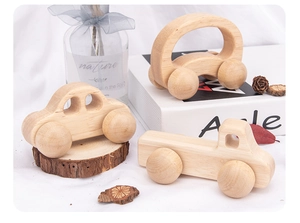 Trois petites voitures en bois naturel pour bambins montrant des bords polis et grain lisse