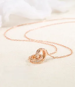 Detailed view of rose gold interlocking double ring pendant with white cubic zirconia