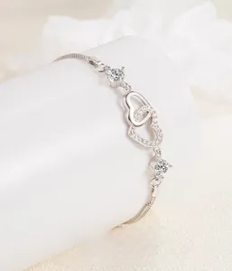 Detail of interlocking S925 silver heart bracelet with sparkling zircon stones