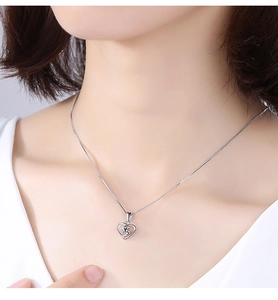 Detail of sterling silver heart pendant necklace with shimmering round-cut crystal