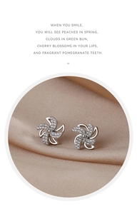 Nahaufnahme von S925 Sterling Silber Windrad-Ohrsteckern mit Zirkonia auf Seide