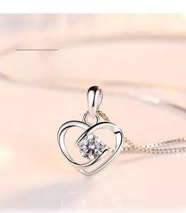 Macro detail of silver heart pendant featuring a large brilliant-cut center gemstone