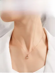 Close-up of rose gold dancing stone pendant necklace on model at the collarbone