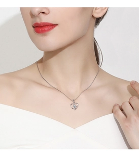 Close-up of sterling silver heart pendant with a sparkling central stone on model