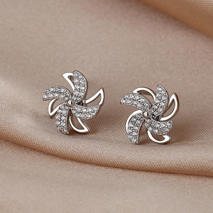 Elegante S925 Sterling Silber Windmühlen Ohrstecker mit Zirkonia auf Seidenhintergrund