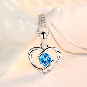 Silver heart pendant necklace featuring a round light blue gemstone on a box chain