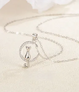 Macro detail of moon and cat pendant with sparkling pave-set zircons on silver chain