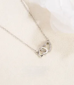 Detail of interlocking silver hearts pendant with cubic zirconia on fine link chain