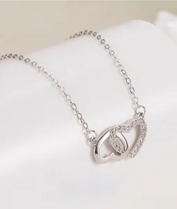 Close-up of interlocking S925 silver hearts pendant with sparkling cubic zirconia pavé
