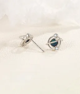 Detail view of S925 silver planet stud earrings with blue-green starry glass and zircon
