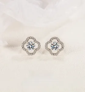 Macro shot of silver four-leaf clover stud earrings with pavé crystals and central zircon