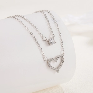 Double-layered silver necklace featuring a sparkling diamond circle and hollow heart pendant